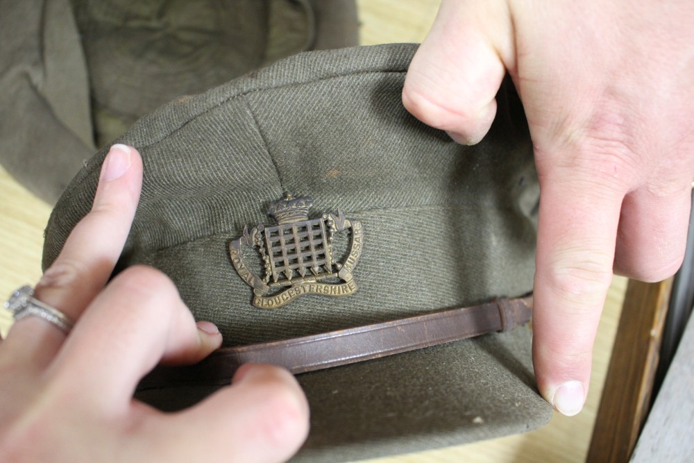 A WWII steel helmet, a Royal Gloucestershire Hussars cap, a Scots Guards? cap, three leather items and a Union Jack